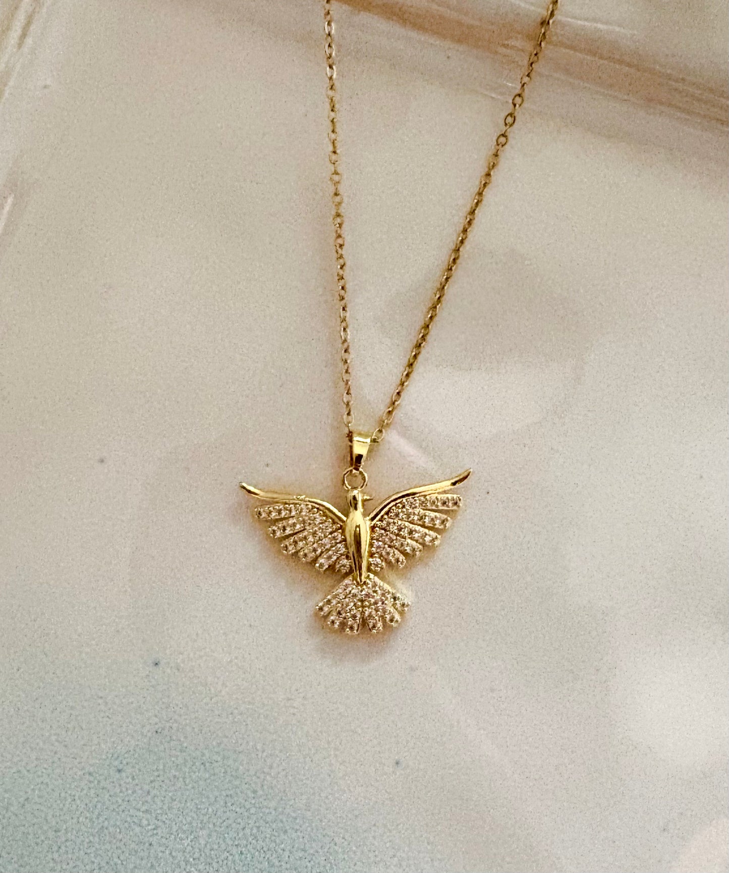 Close-up of gold bird pendant with sparkling cubic zirconia stones