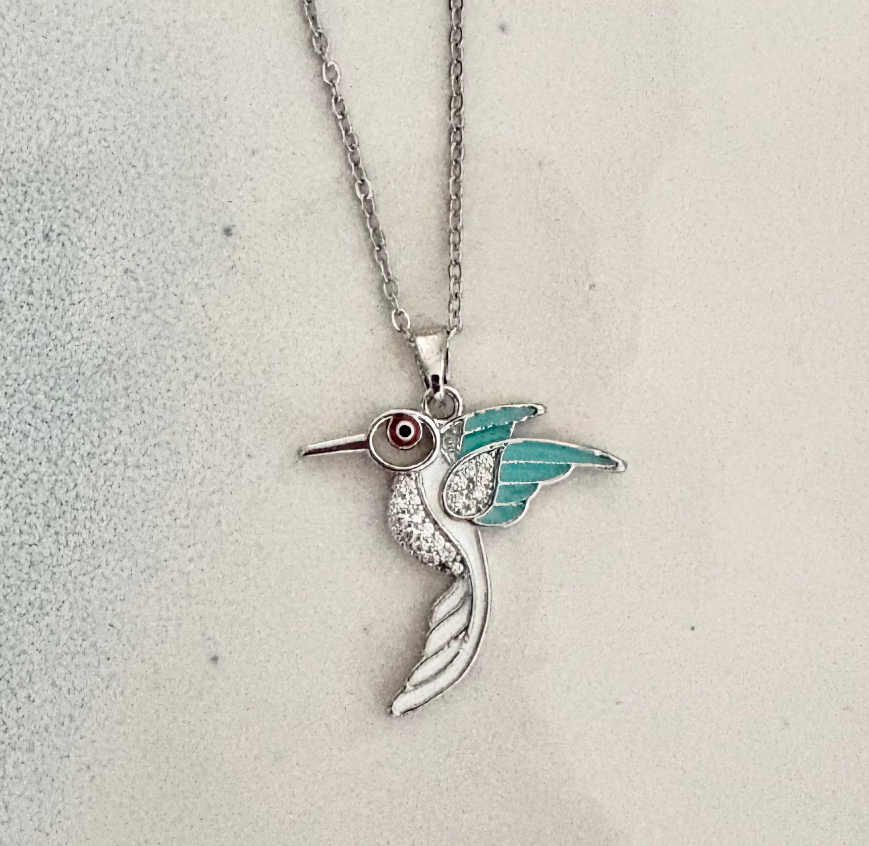 Silver hummingbird necklace with turquoise enamel wings