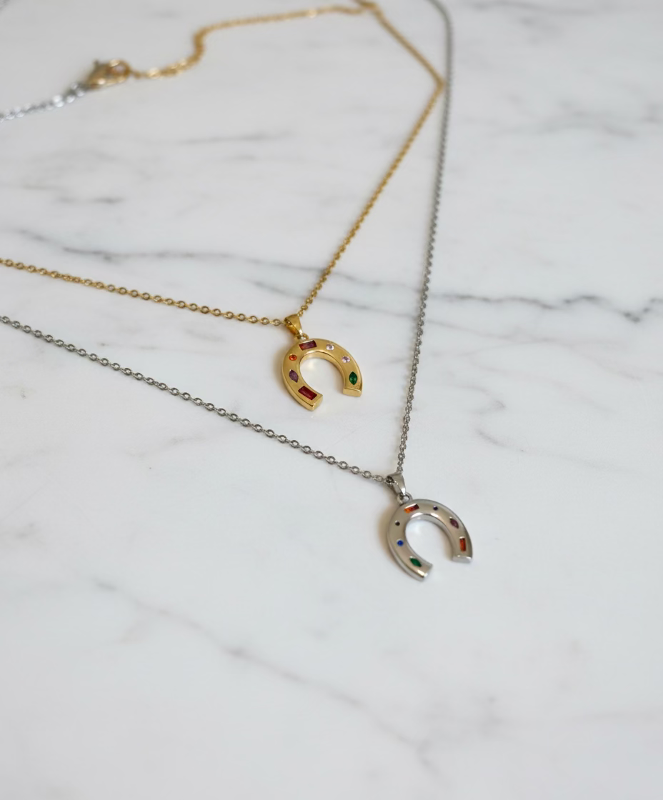 Gold and silver horseshoe necklaces displayed on jewelry mannequin