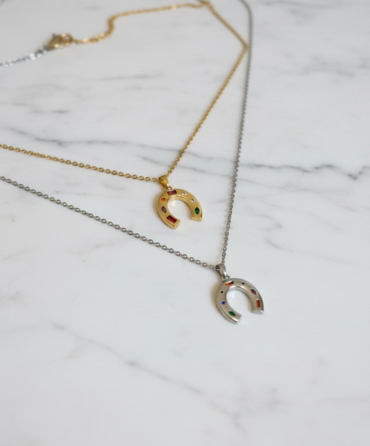 Gold and silver horseshoe necklaces displayed on jewelry mannequin