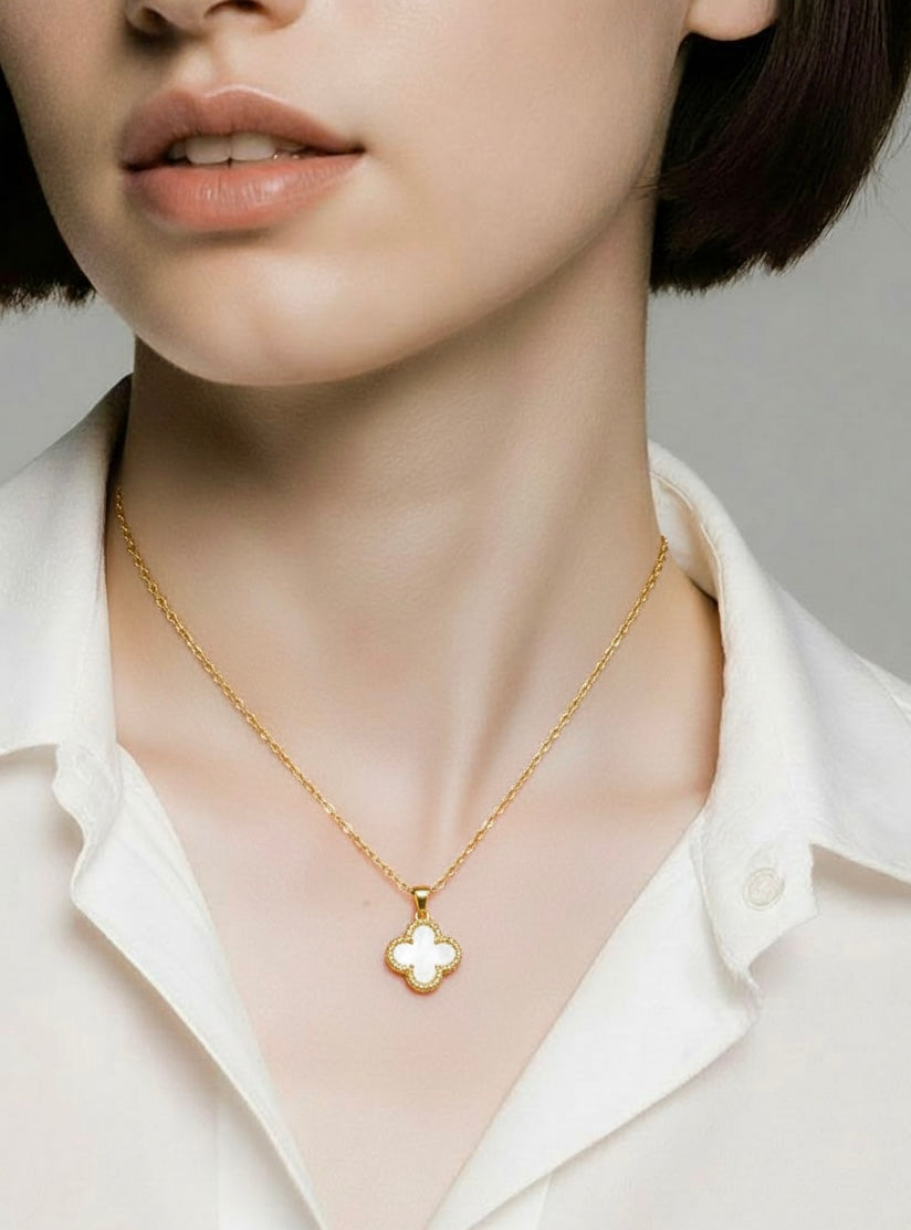 Elegant gold clover necklace displayed on neutral background