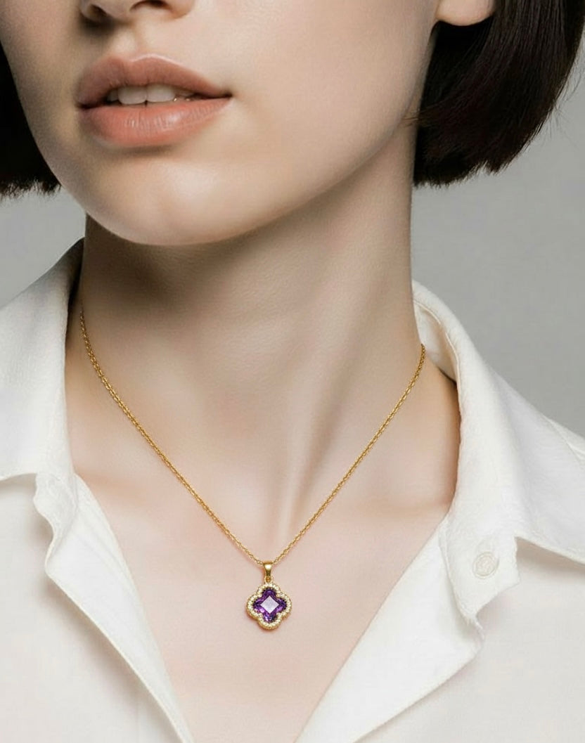 Close-up of a person wearing a gold necklace with a purple pendant.