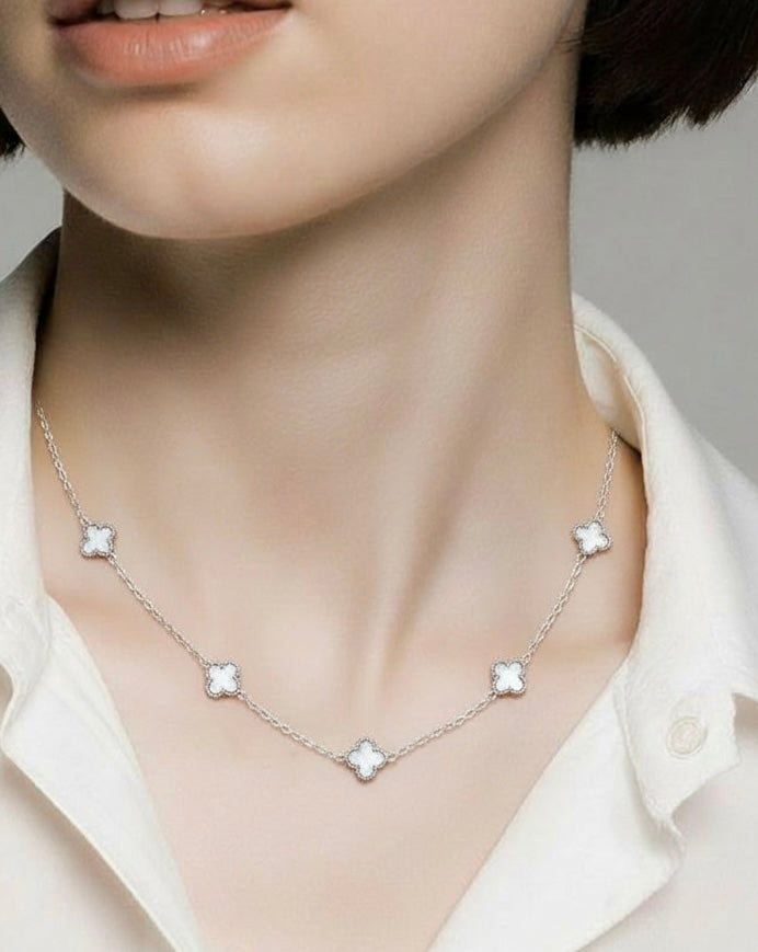 Necklace with star-shaped pendants on a mannequin wearing a white shirt.