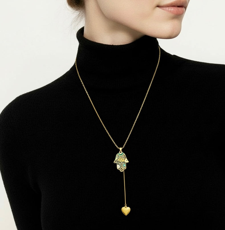 Gold necklace with a pendant worn by a person in a black turtleneck