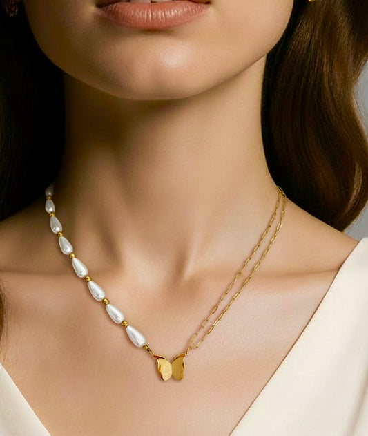 Close-up of a woman wearing a gold necklace with a heart pendant and a pearl necklace.