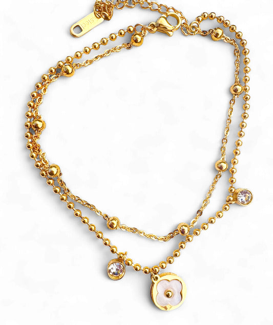 Gold chain necklace with heart pendant on a white background