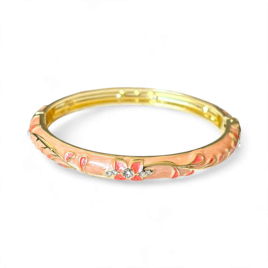 Gold bangle with floral design and crystals on a white background