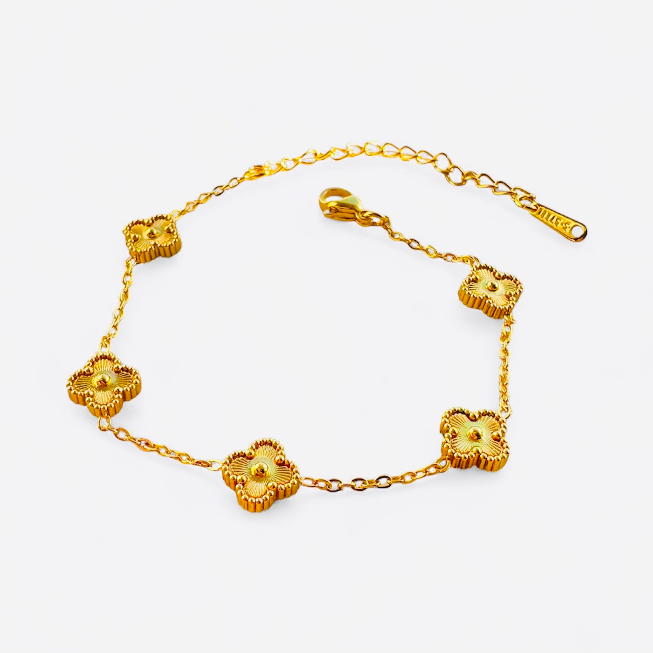 Gold bracelet with floral designs on a white background