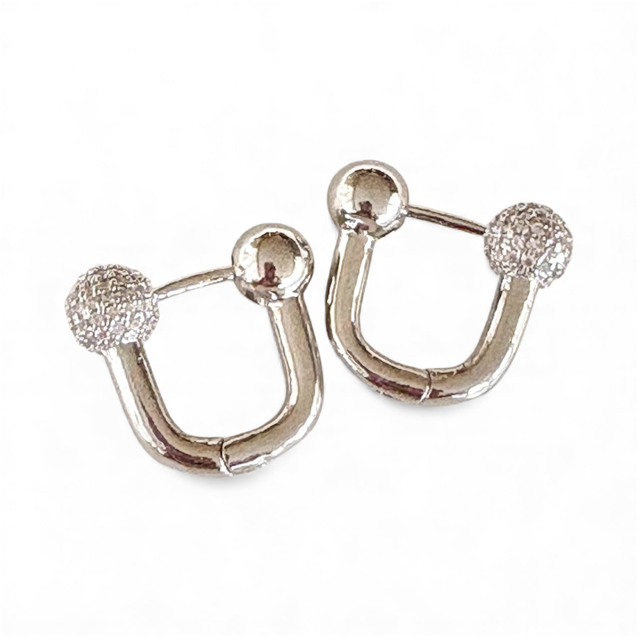 Front view of U‑shaped silver hoop earrings with polished and textured ball ends