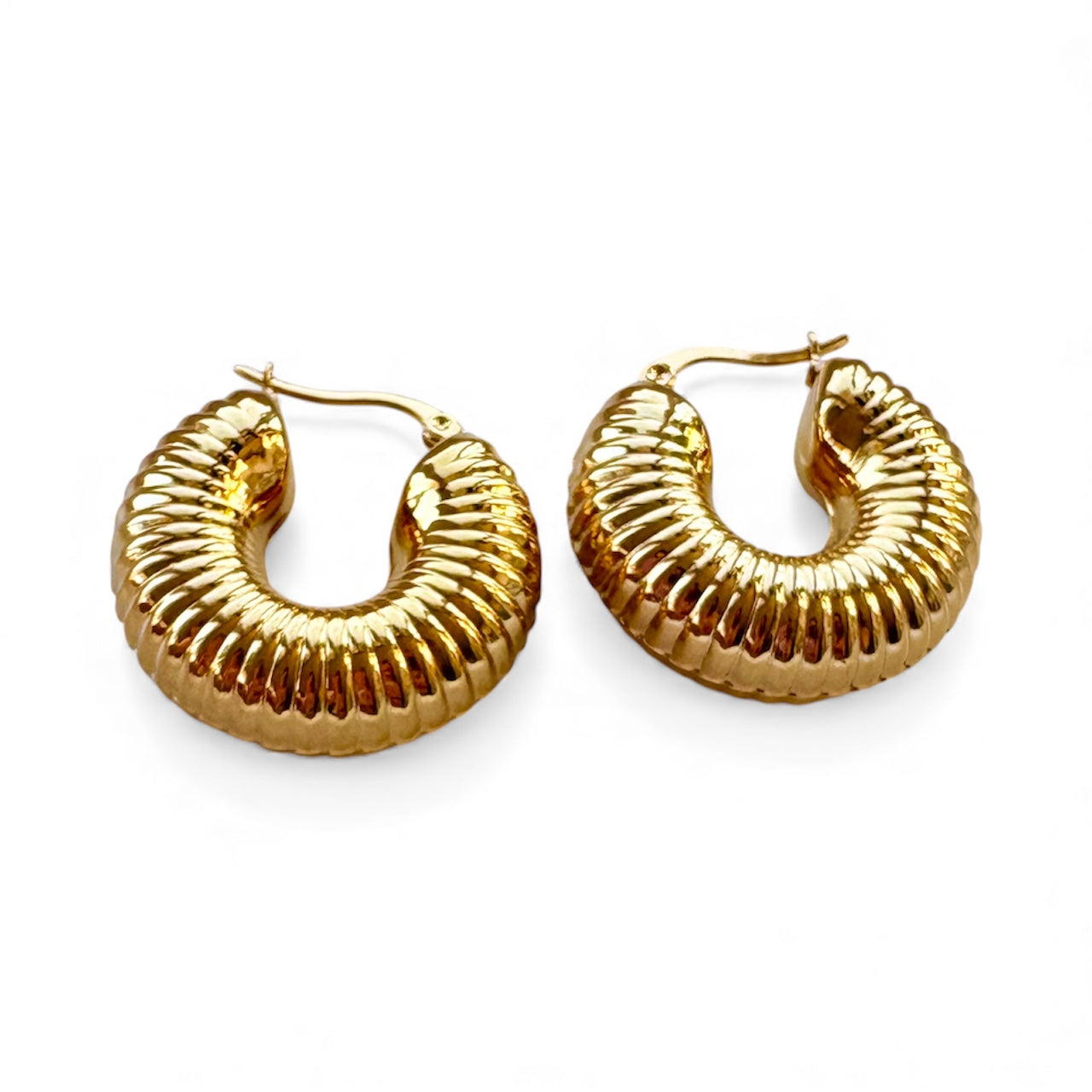 Front view of ridged gold hoop earrings with a ribbed, chunky design and latch closure