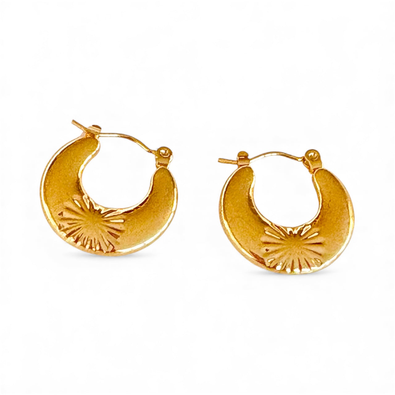 Front view of 2 cm gold crescent hoop earrings with a starburst engraving near the bottom