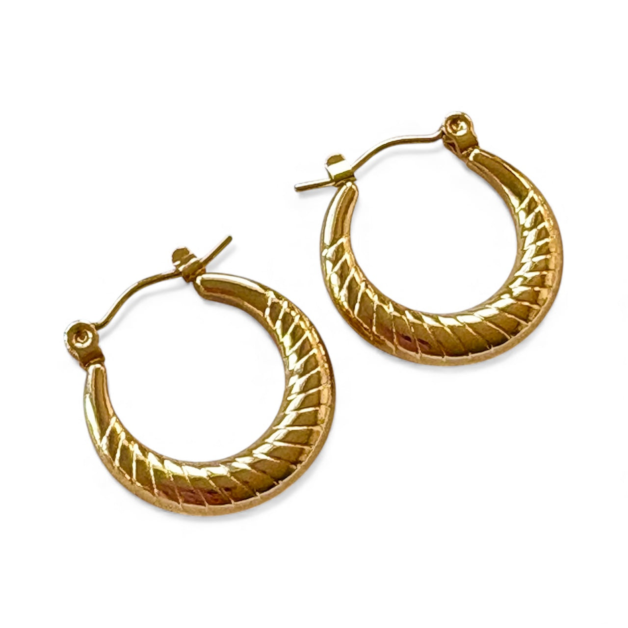 Front view of 2 cm twisted gold hoop earrings with an engraved ribbed pattern and latch closure