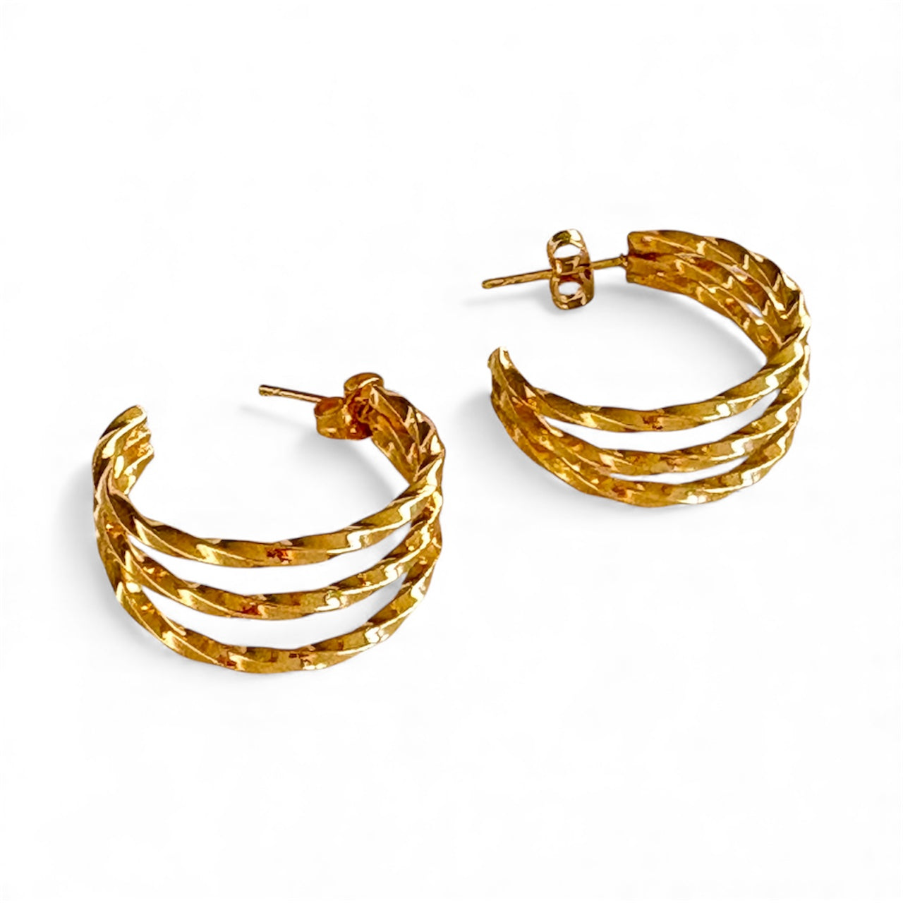 Gold hammered triple‑band hoop earrings with a 2 cm diameter, showcasing layered bands and stud posts