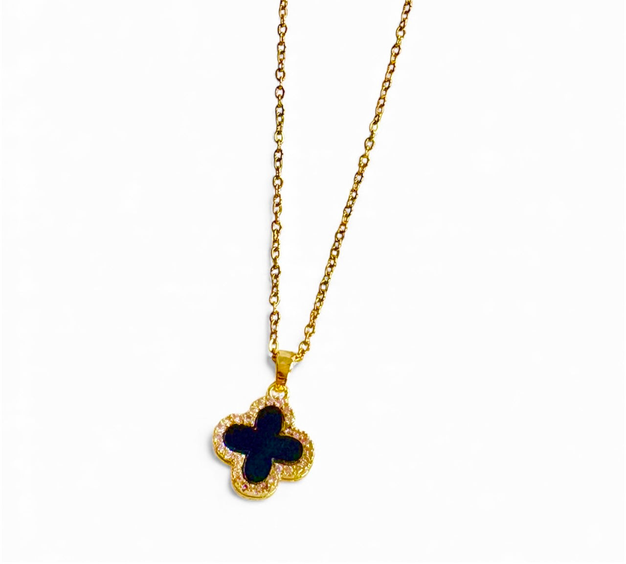 Gold necklace with a clover-shaped pendant featuring a blue stone on a white background