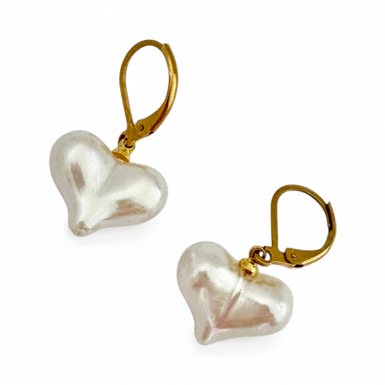 Heart-shaped pearl earrings with gold hooks on a white background