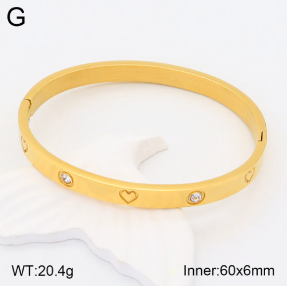 Gold bracelet with heart and diamond designs on a white background