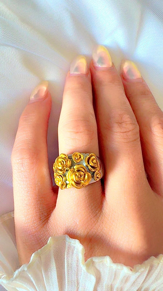 Gold rose cluster ring with detailed floral design displayed on hand