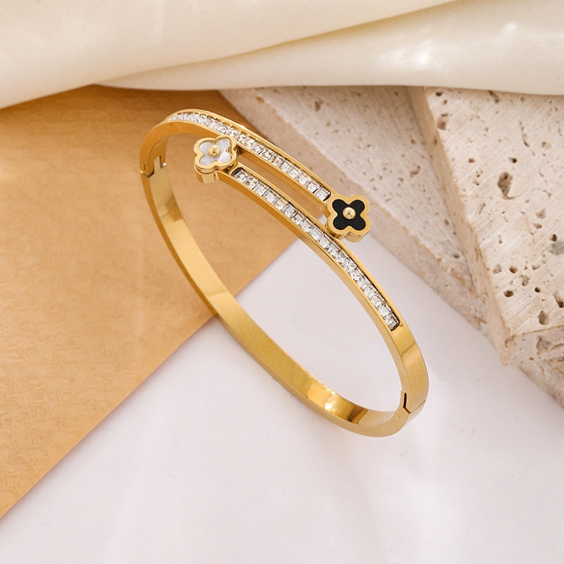 Gold bracelet with floral designs on a light background