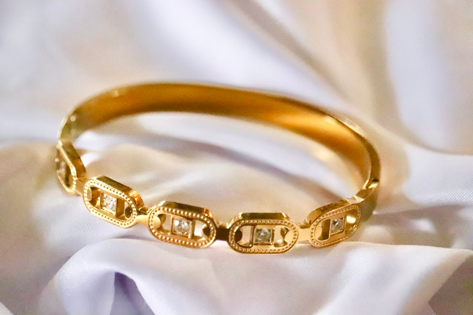 Gold bracelet on a white fabric