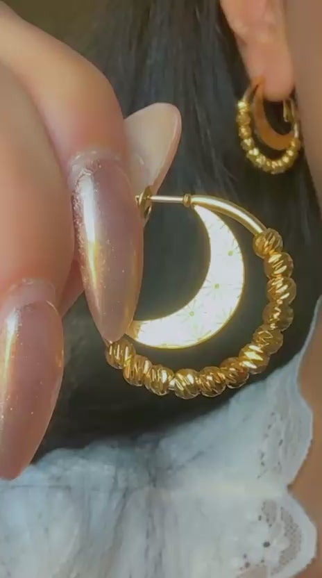 Close-up of celestial hoop earrings with engraved crescent moon design