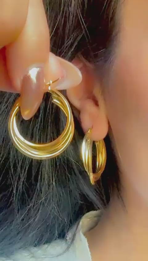 Close-up of layered gold hoop earrings with polished shine