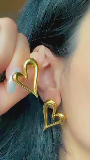 Gold open heart statement earrings displayed on ear